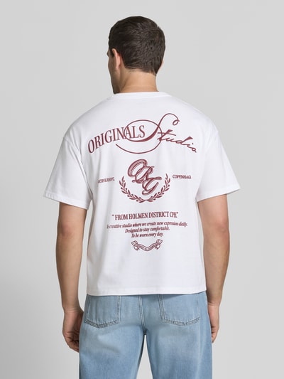 Männermodel trägt Regular Fit T-Shirt mit überschnittenen Schultern von JACK & JONES, Weiß mit Statement-Print auf der Rückseite, Baumwoll-Mix, Ganzkörperansicht Rückansicht.
