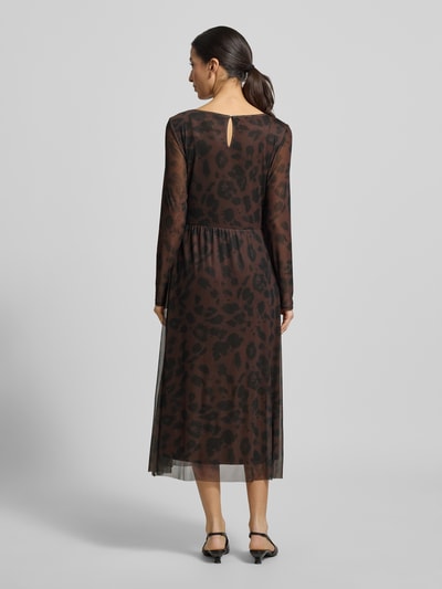 Kobiece modelka nosi Tailliertes Freizeitkleid mit Allover-Muster od Tom Tailor, szyfon, wzór na całej powierzchni, długość midi, okrągły dekolt, długi rękaw, prosty dół, zapięcie guzik i oczko, widok całej sylwetki z tyłu.