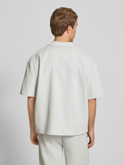 Männermodel trägt Relaxed Fit Freizeithemd mit Reverskragen Modell 'Troy' von Pegador, Strukturmuster, hell, Kurzarm, Ganzkörperansicht Rückansicht.
