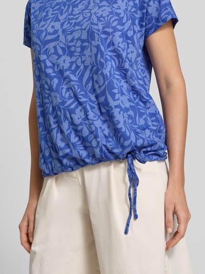 Frauenmodel trägt T-Shirt mit Kordelzug am Saum und Rundhalsausschnitt von Betty Barclay im blau gemusterten Material-Mix, Straight Fit, Damen T-Shirt, Nahaufnahme Oberkörper. Rückenlänge bei Größe 36: 60 cm.