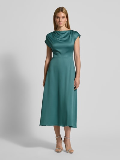 Frauenmodel trägt Relaxed Fit Midikleid mit Stoffband von Christian Berg Cocktail in Satin, türkis, gerader Ausschnitt, kurzärmelig; Ganzkörperansicht von vorne.