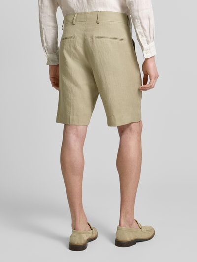 Männermodel trägt Shorts mit französischen Eingrifftaschen Modell 'Troy' von Tiger Of Sweden in Beige, gerader Schnitt, Leinenstruktur, Ganzkörperansicht Rückansicht.