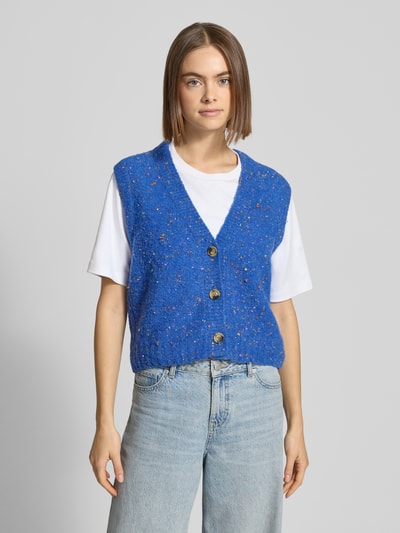Frauenmodel trägt Regular Fit Pullunder aus Schurwoll-Mix von Marc O'Polo Denim in Optik: unifarben, mehrfarbig, Knopfleiste, Strick-Textur, Label-Stitching-Applikation, tiefer V-Ausschnitt, Rumpfabschluss gerippt, Ganzkörperansicht von vorne.