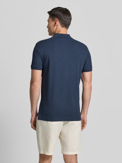 Männermodel trägt Slim Fit Poloshirt mit Logo-Stitching von Lerros in Dunkelblau, strukturierte Baumwoll-Mix-Oberfläche, Ganzkörperansicht Rückansicht.