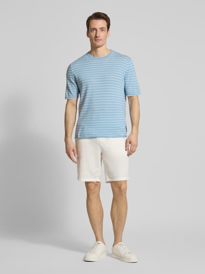 Mannenmodel draagt T-shirt in tricotlook met kasjmier-aandeel van FTC Cashmere, mix van katoen en lyocell, recht model, halflange mouwen, ruglengte 65 cm bij maat 50, lichtblauw met witte strepen, geheelopname van voren.