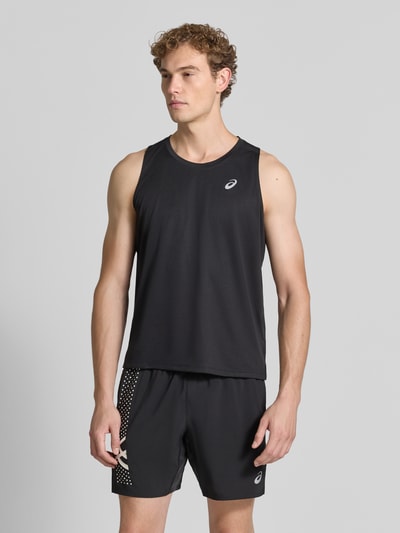 Mężczyzna model nosi top Regular Fit Top mit Logo-Print Modell 'Core' von ASICS TIGER, czarny kolor, krój regular fit, okrągły dekolt, nadruk z logo, Długość tyłu w rozmiarze M: 68 cm, Ganzkörperansicht von vorne.
