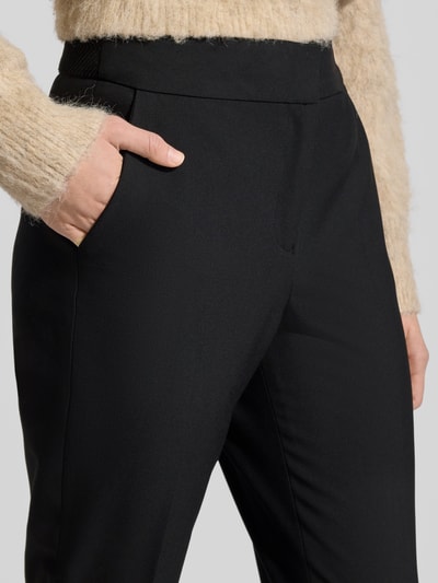 Frauenmodel trägt Regular Fit Schmale Hose mit Bügelfalten von s.Oliver BLACK LABEL, Optik: Unifarben, Nahaufnahme Oberkörper. Passform: Regular Fit, Mid Waist, Label-Stitching, elastischer Bund mit Struktur, Schiebehaken und verdeckter Reißverschluss, Bundabschluss elastisch, seitliche Eingrifftaschen, angedeutete Gesäßtaschen.