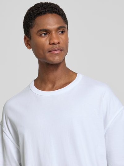 Männermodel trägt weißes Herren T-Shirt mit Rundhalsausschnitt Modell 'FAZY' von American Vintage aus Reine Baumwolle, Relaxed-Fit, Nahaufnahme Oberkörper. Rückenlänge Größe M/L: 70 cm.