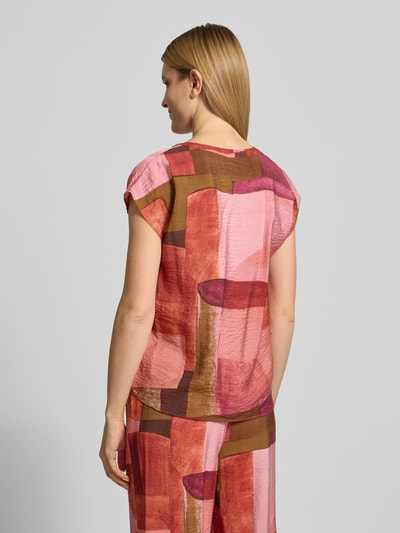 Vrouwenmodel draagt Regular Fit blouse uit viscosemix model 'Catania' van Soyaconcept in roze, rood en bruin met tuniekhals, kapmouwen, ruglengte maat S 55 cm, mouwlengte maat S 20 cm, ganzekörperaanzicht rugaanzicht.