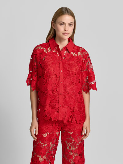 Frauenmodel trägt Regular Fit Bluse aus Spitze Modell 'GALA' von YAS in leuchtendem Rot mit Hemdblusenkragen und Knopfleiste, Ganzkörperansicht von vorne.