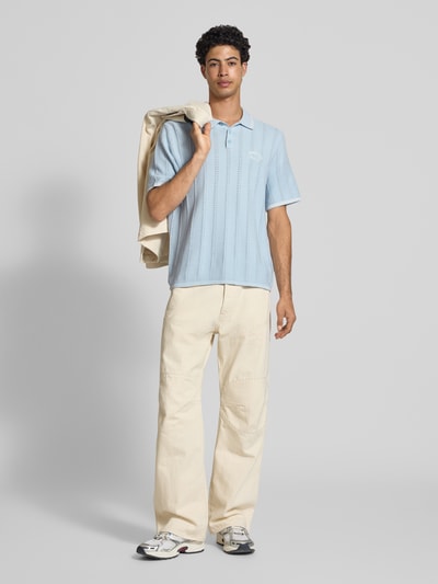 Męski model nosi Regular Fit Poloshirt in Strick-Optik Modell 'Menton' od Jack & Jones, czysta bawełna, krój regular fit, jasnoniebieskie, prążkowana faktura, krótki rękaw, długość tyłu w rozmiarze M: 70 cm, pełen widok z przodu.