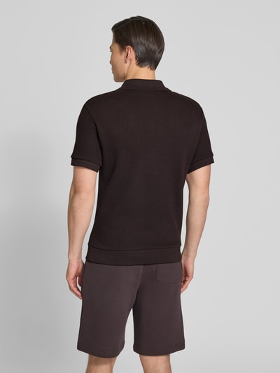 Männermodel trägt Regular Fit Poloshirt aus reiner Baumwolle von Lacoste, Optik: Unifarben, Struktur, Kurzarm, Ganzkörperansicht Rückansicht.