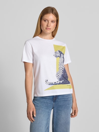 Frauenmodel trägt T-Shirt mit Motiv-Print und Rundhalsausschnitt von Marc Cain in Weiß mit gelbem und blauem Print, Regular Fit, reine Baumwolle, Rückenlänge 58 cm, Ganzkörperansicht von vorne.