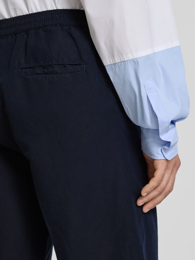 Männermodel trägt Straight Fit Shorts aus Leinen-Mix von Filippa K in Dunkelblau, sichtbare Gesäßtasche, Nahaufnahme Rückansicht.