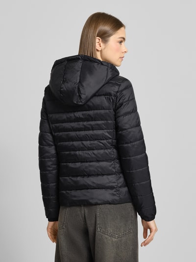 Modelka kobieca ma na sobie Regular Fit Steppjacke mit Kapuze Modell 'TAHOE' od Only, czarna, jednolita, nylon, widok całej sylwetki z tyłu.