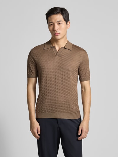 Männermodel trägt Slim Fit Poloshirt mit Lyocell-Anteil von Emporio Armani in Braun, Kurzarm, Strick-Optik, Ganzkörperansicht von vorne.