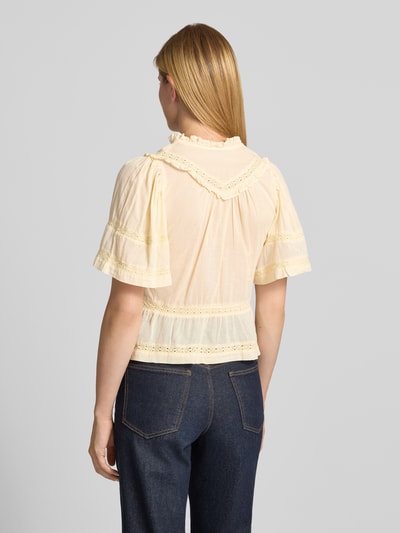 Frauenmodel trägt Blusenshirt mit V-Ausschnitt und Rüschen Modell 'Evienne' von Neo Noir aus reiner Baumwolle in zartem Gelb, tailliertem Schnitt und kurzen Ärmeln; Rückenlänge 51 cm, Ärmellänge 31 cm, Ganzkörperansicht Rückansicht.