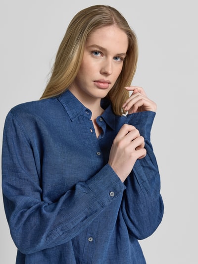 Frauenmodel trägt Hemdbluse aus Leinen mit Kentkragen Modell 'MIRA' von 0039 Italy in Dunkelblau, sichtbare Knopfleiste, Nahaufnahme Oberkörper. Regular Fit, Sportmanschetten, reine Leinenstruktur, Rückenlänge 68 cm, Ärmellänge 62 cm.