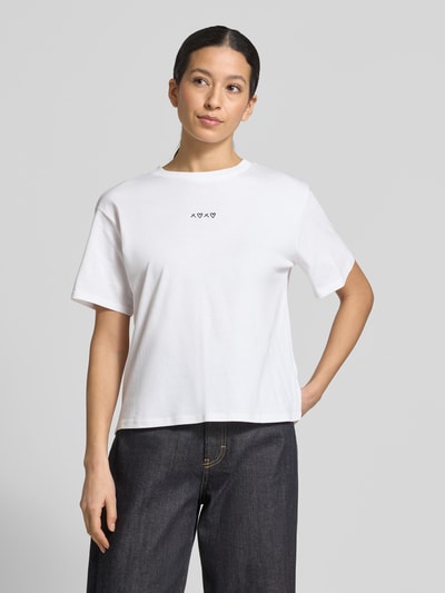 Modelka kobieca nosi Boxy Fit T-Shirt aus reiner Baumwolle von Tom Tailor Denim, biały, jednolity, z okrągłym dekoltem, krótkim rękawem, motyw haftu, drobny prążkowany materiał, damski T-shirt, widok całej sylwetki z przodu.