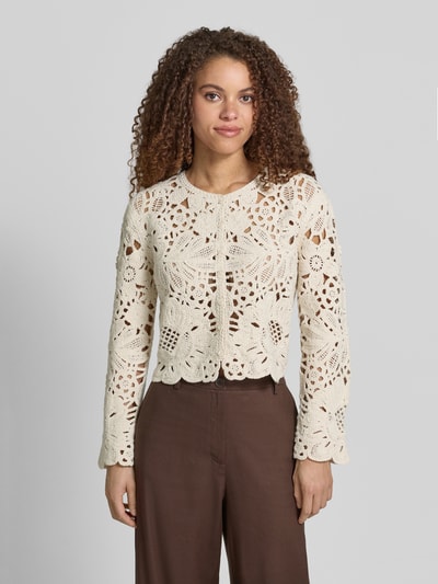 Frauenmodel trägt Cardigan aus Häkelspitze mit Rundhalsausschnitt von Jake*s Collection aus reiner Baumwolle, gerader Schnitt, Knopfleiste, cremefarbene Häkelspitze, strukturierte Textur, Kombi mit brauner Hose, Ganzkörperansicht von vorne.