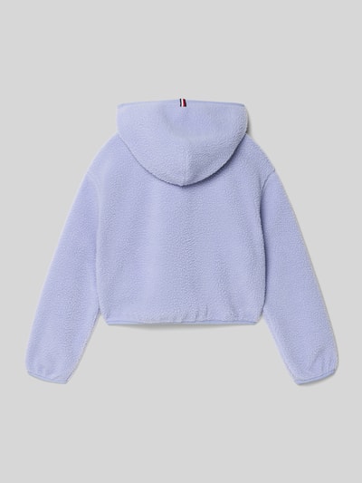Mädchen trägt Regular Fit Bluza rozpinana w imitacji futerka od Tommy Hilfiger Teens, efekt: jednolity kolor, imitacja futerka, krój regular fit, zamek błyskawiczny, wyhaftowane logo, detal z logo, szlufki na pasek, kaptur, długi rękaw, elastyczne zakończenia rękawów i dołu, boczne wpuszczane kieszenie; wykończenie materiału: imitacja futerka. Ganzkörperansicht Rückansicht.