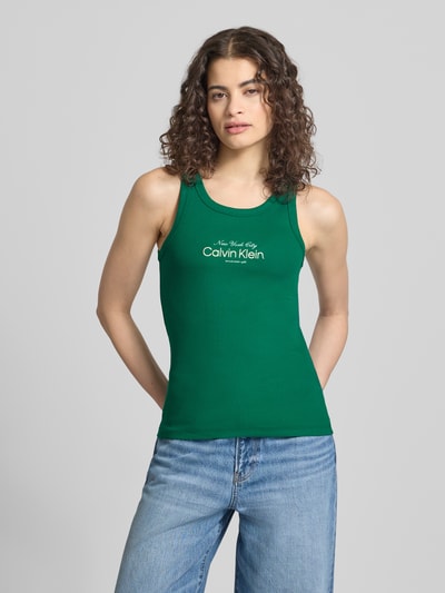 Kobiece model prezentuje top z wyhaftowanym logo, zielony, dopasowany krój, mieszanka bawełny, model 'CONTOUR' od Calvin Klein Jeans, dekolt w łódkę, długość tyłu w rozmiarze S: 48 cm, widok całej sylwetki z przodu.