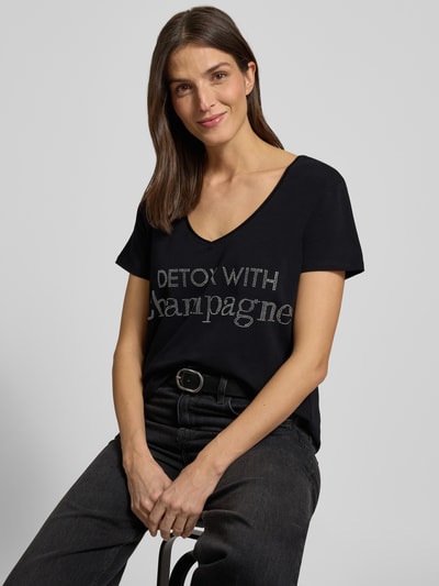 Vrouwenmodel draagt T-shirt met Labeldetail van miss goodlife, zwart, mix van katoen en elastaan, los model, V-hals, ruglengte 68 cm, Nahaufnahme Oberkörper.