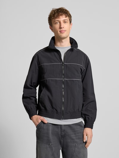 Männermodel trägt Regular Fit Blouson mit Kontraststreifen Modell 'HEIGHTS PIPPING JACKET' von Levi's®, unifarben, Reißverschluss, Stehkragen, seitliche Eingrifftaschen, gerippte Abschlüsse, Ganzkörperansicht von vorne.