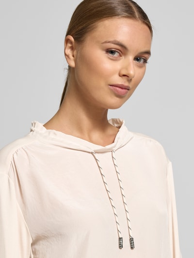 Vrouwenmodel draagt Shirt met lange mouwen met ronde hals van Marc Cain, mix van katoen en elastaan, los model, tunnelkoord, ribboorden. Nahaufnahme bovenlichaam. Ruglengte maat 36: 53 cm.