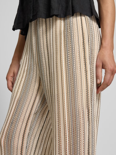 Frauenmodel trägt Relaxed Fit Strickhose mit Allover-Muster Modell 'DEMI' von Vero Moda, gestreift, Struktur, Lochstrickmuster, Nahaufnahme Oberkörper.