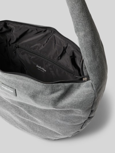 Produktfoto, Shoulder Bag aus reiner Baumwolle in Denim-Optik von Studio Noos, graue Farbe, sichtbares Hauptfach mit Reißverschluss und Logo-Detail, glatte Textur, Innenfach mit Reißverschluss, Maße laut Kontext.