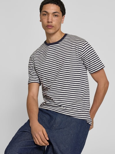 Männermodel trägt T-Shirt mit Rundhalsausschnitt von Closed, Weiß mit dunkelblauen Streifen, reine Baumwolle, Ganzkörperansicht von vorne.