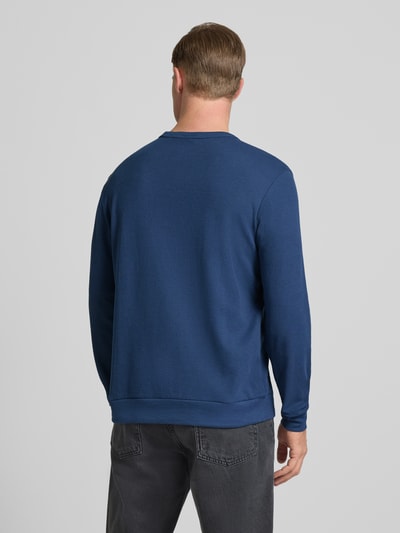 Männermodel trägt Regular Fit Langarmshirt aus Baumwoll-Mix von Tom Tailor, Optik: Unifarben, Waffel-Struktur, Ganzkörperansicht Rückansicht.
