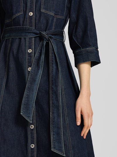 Kobiece model prezentuje sukienka koszulowa z wiązanym paskiem od Betty Barclay, mieszanka bawełny i lyocellu, linia a, sukienka midi, imitacja denimu, kołnierzyk koszulowy, listwa guzikowa, długość tyłu w rozmiarze 36: 121 cm, szerokość w rozmiarze 36: 51 cm, długość rękawów w rozmiarze 36: 43 cm, zbliżenie na górną część sylwetki
