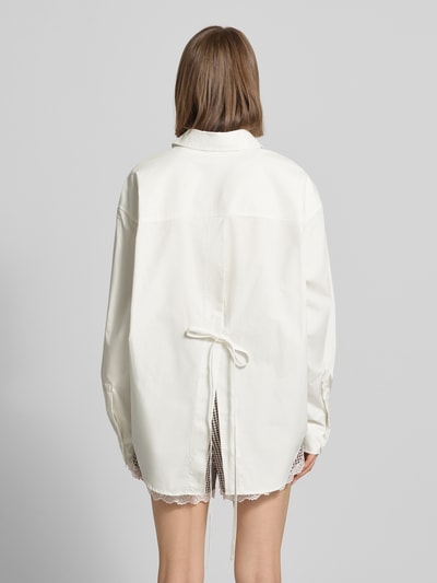 Frauenmodel trägt Oversized Hemdbluse mit Statement-Stitching Modell 'Leya' von OH APRIL aus Reine Baumwolle, abgerundeter Saum, Oversized-Fit, Hemdblusenkragen, verdeckte Knopfleiste, Statement-Stitching am Ärmel, Rückenlänge 78 cm, Ärmellänge 61 cm, Farbe Weiß, strukturierte glatte Textur, Ganzkörperansicht Rückansicht.