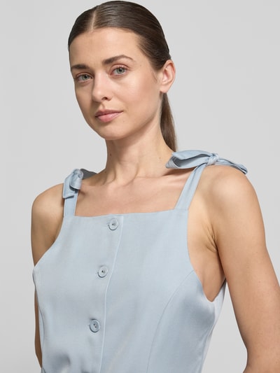 Kobiece model prezentuje Top mit Knopfleiste von Little Mistress w jasnoniebieskim kolorze, materiał-mix z domieszką stretchu, krój slim fit, ramiączka wiązane, guziki z przodu, zbliżenie na górną część ciała