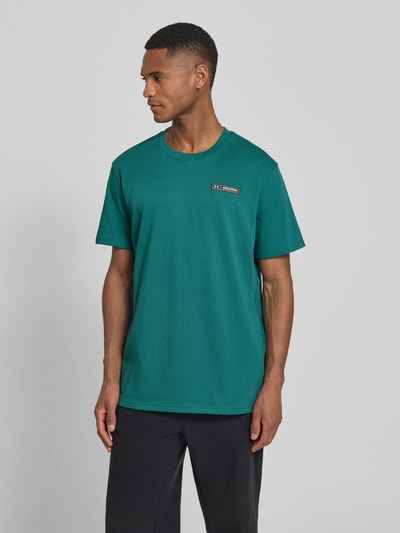 Männermodel trägt Regular Fit T-Shirt mit Logo-Applikation von Under Armour in Grün, Baumwoll-Mix, Rundhalsausschnitt, Ganzkörperansicht von vorne