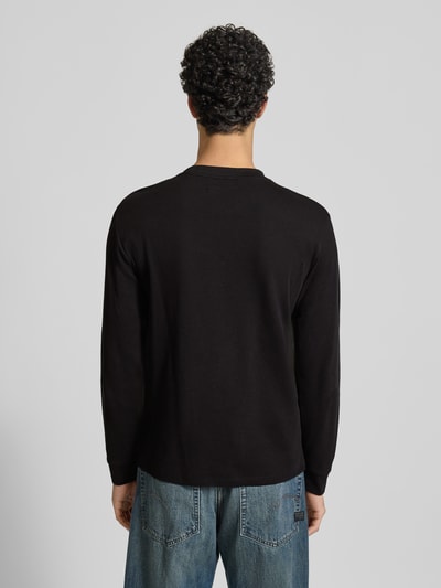 Männermodel trägt Sweatshirt mit Stehkragen von Replay, schwarze Farbe, Reine Baumwolle, Waffel-Design, Gerade Passform, Ganzkörperansicht Rückansicht.