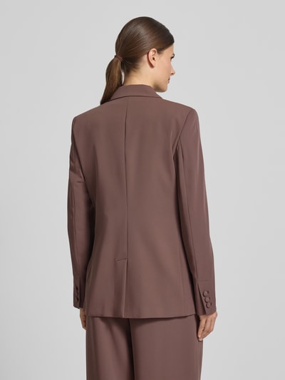 Frauenmodel trägt Regular Fit Blazer mit Pattentaschen von Christian Berg Cocktail, Material-Mix mit Stretch-Anteil, Zweireiher, Reverskragen, Rückenlänge bei Größe 36: 70 cm, Farbe Braun, glatte Struktur, Ganzkörperansicht Rückansicht.