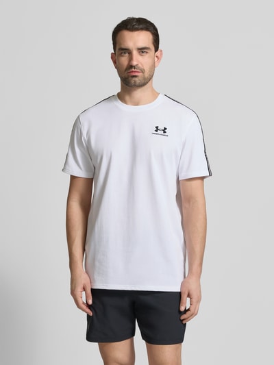 Męski model nosi Regular Fit T-Shirt mit Logo-Stitching Modell 'Icon' von Under Armour, biały, bawełniany, krój regular fit, przód, zbliżenie do połowy ciała.