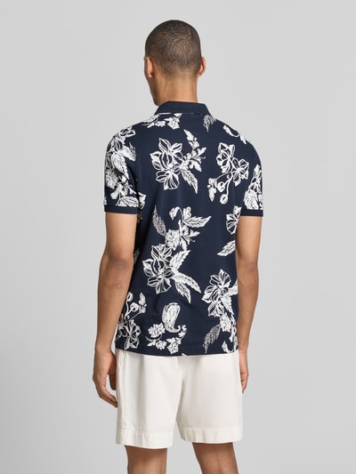 Männermodel trägt Modern Fit Poloshirt mit Label-Detail van Lerros, donkerblauw-wit bloemmotief, puur katoen, polokraag, ruglengte maat M 74 cm, korte knoopsluiting, labeldetail, Ganzkörperansicht Rückansicht.