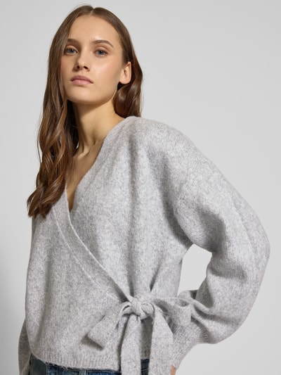 Frauenmodel trägt Regular Fit Cardigan mit Woll-Anteil Modell 'KIRA' von ONLY, Optik: Unifarben, Melange, Strickoptik, Wickeloptik, Nahaufnahme Oberkörper.