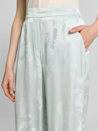 Frauenmodel trägt Weite Hose aus reiner Viskose von Calvin Klein Womenswear mit Allover-Muster in hellen Pastelltönen, Nahaufnahme Oberkörper.