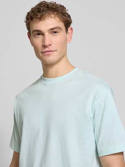 Mężczyzna nosi Regular Fit T-Shirt aus reiner Baumwolle von MCNEAL, jasnoniebieski, krój regular fit, okrągły dekolt, krótki rękaw, widok na górną część ciała z przodu.