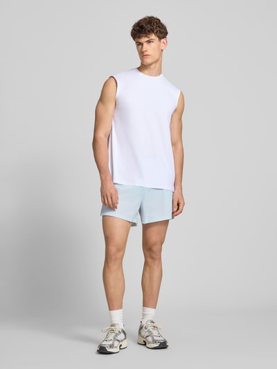 Männermodel trägt Shorts mit elastischem Bund Modell 'ERUDITO' von Ellesse aus Material-Mix mit Stretch-Anteil, hellblaue Farbe, Regular-Fit, Ganzkörperansicht von vorne.