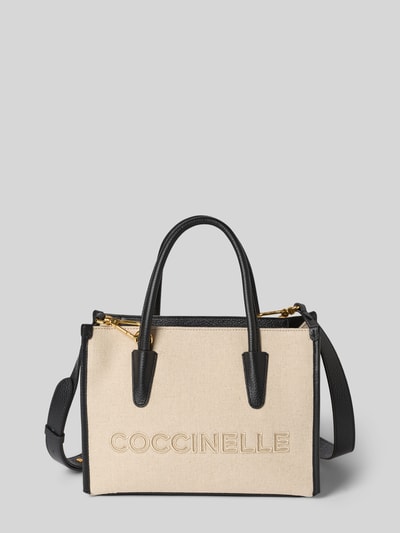 Produktfoto, Handtasche mit Label-Stitching von Coccinelle aus beigefarbenem Stoff mit schwarzen Details, Tragehenkel, Schulterriemen, Hauptfach mit Reißverschluss, Maße: Breite 27 cm, Länge 20 cm, Tiefe 13 cm, Länge Schulterriemen 105 cm