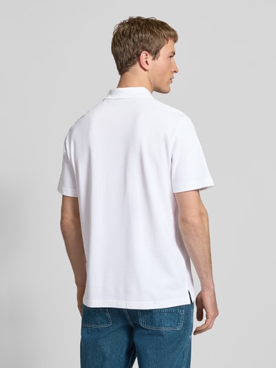 Männermodel trägt Easy Fit Poloshirt mit Polokragen von Calvin Klein Jeans, reine Baumwolle, weiß, Label-Stitching, Ganzkörperansicht Rückansicht.