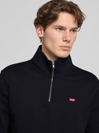 Männermodel trägt Regular Fit Sweatshirt aus reiner Baumwolle von Levi's®, dunkle Farbe, glatte Textur, Nahaufnahme Oberkörper. Herren Sweatshirt.