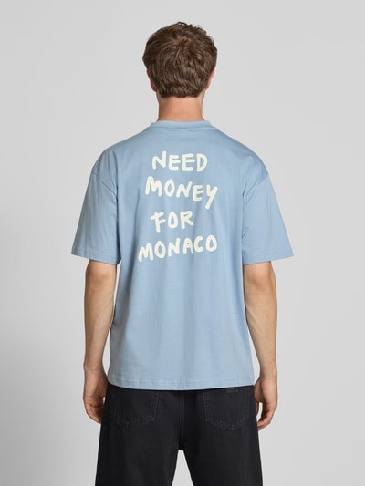 Männermodel trägt Loose Fit T-Shirt aus reiner Baumwolle Modell 'MONEY' von Only & Sons, Optik: Unifarben, Statement-Print, Ganzkörperansicht Rückansicht.