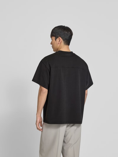 Männermodel trägt Relaxed Fit T-Shirt mit Logo-Stitching von WON HUNDRED aus reiner Baumwolle, schwarze Farbe, Ganzkörperansicht Rückansicht.